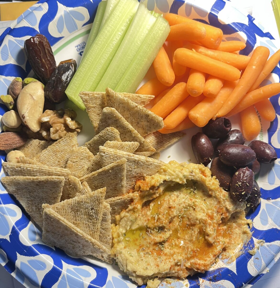 Bog standard summer lunch: hummus with olive oil and spices, whole grain crackers, veggies, olives, nuts, and dates for dessert.