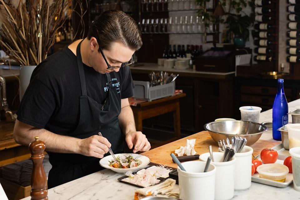 Pasjoli chef de cuisine Jack Joyce plates a tomato dish during menu testing.