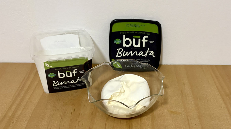 Open container of Buf burrata next to serving bowl
