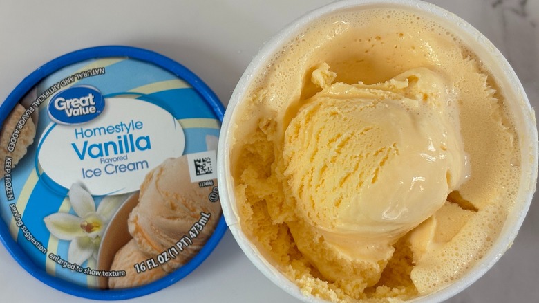 Top-down view of open tub of Great Value Homestyle Vanilla ice cream next to lid on white table