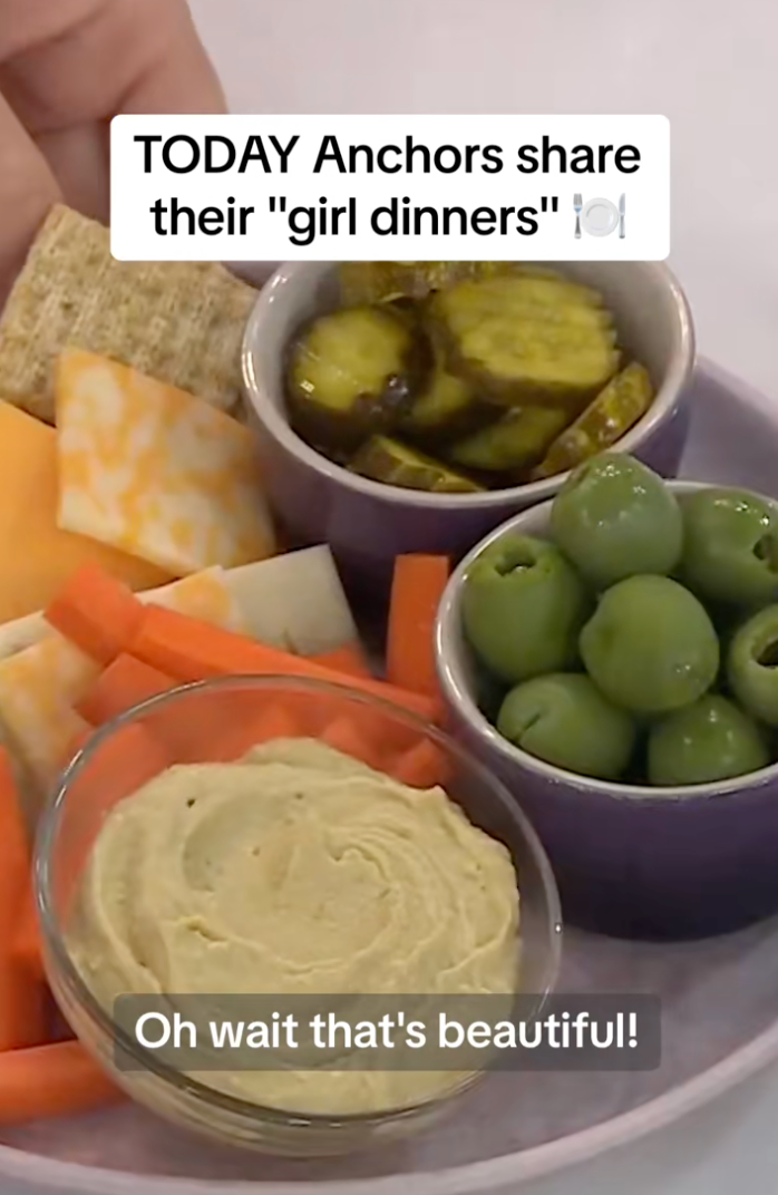 Plate with cheese, pickles, green olives, carrot sticks, and hummus arranged for a "girl dinner" concept. Text: "Oh wait that's beautiful!"