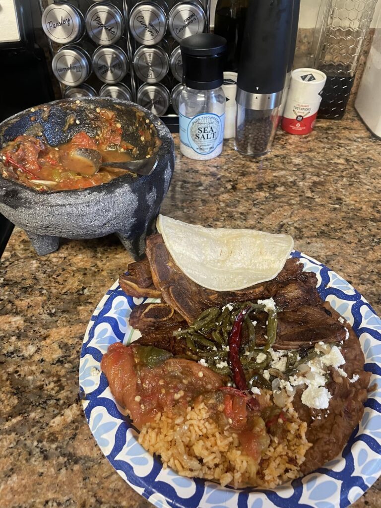 Costillas con arroz frijoles refritos y nopales.