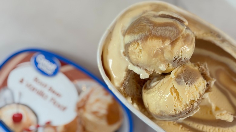 Top-down view of open tub of Great Value Root Beer and Vanilla Float ice cream next to lid on white table
