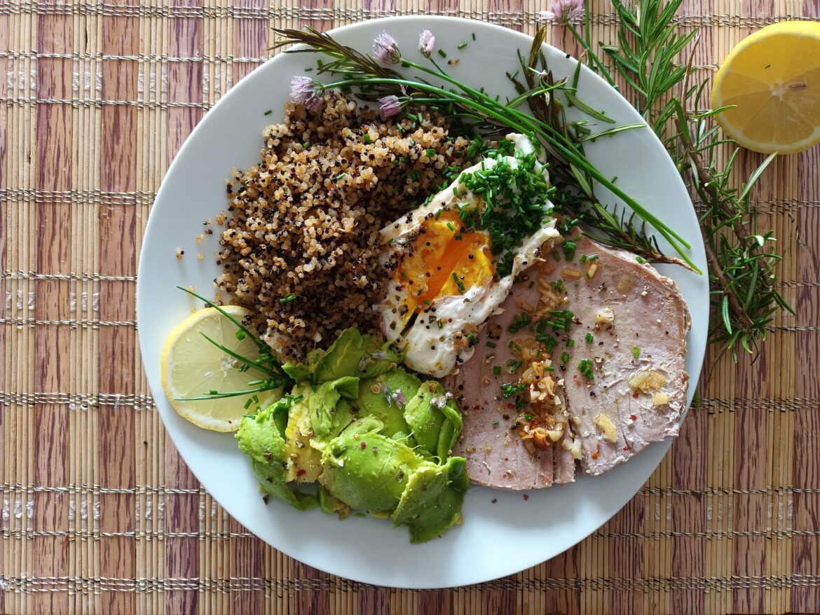 Tuna, quinoa, avocado and an egg with fresh herbs.