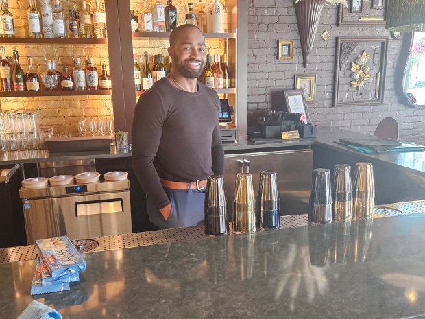 Manager Marshon Crowder stands in the bar area at Touche French Creole, which opened in April at 6 N. River St. in downtown Aurora. (David Sharos / For The Beacon-News)