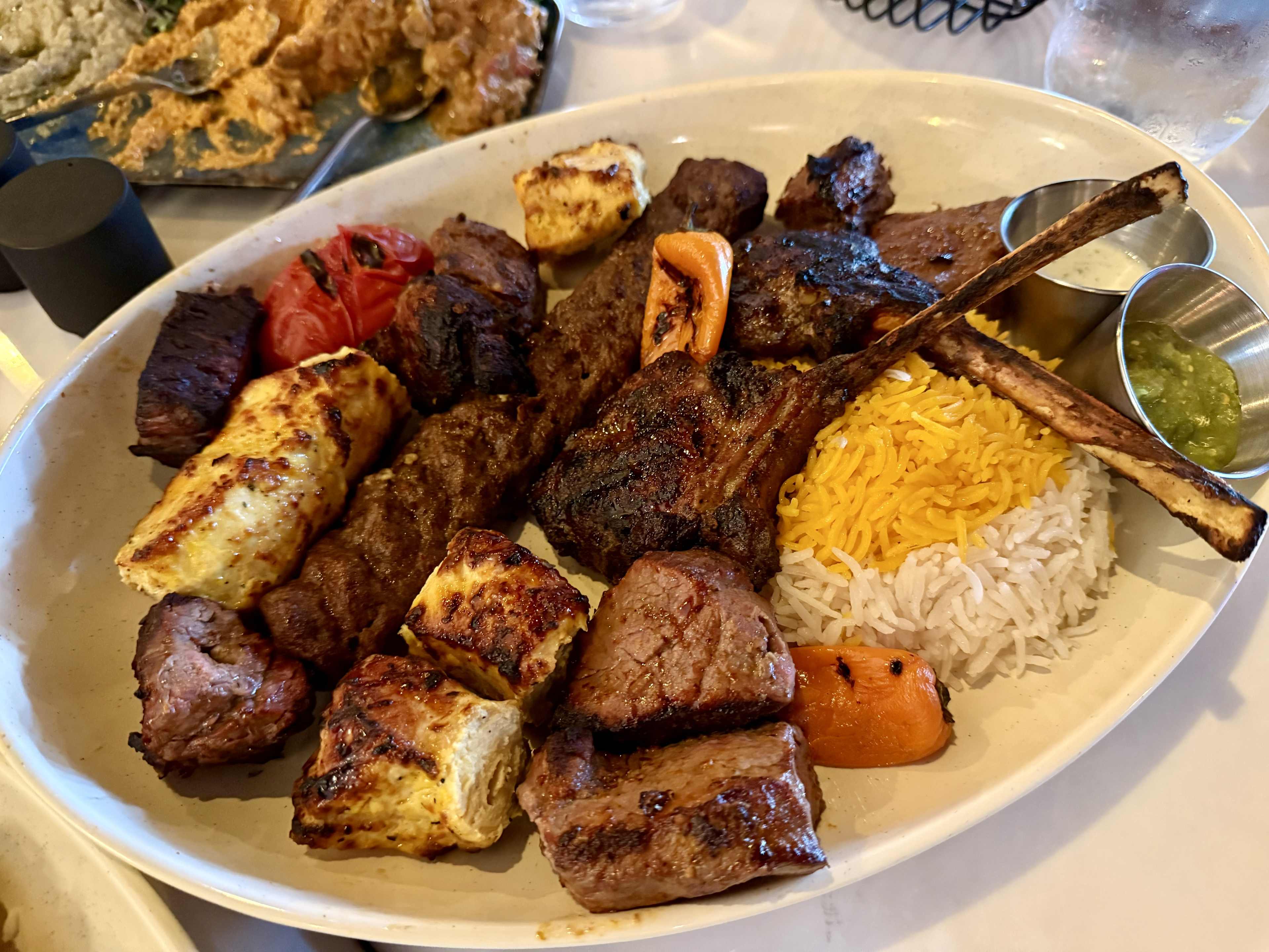 A platter with lamb chops, rice, and chicken.