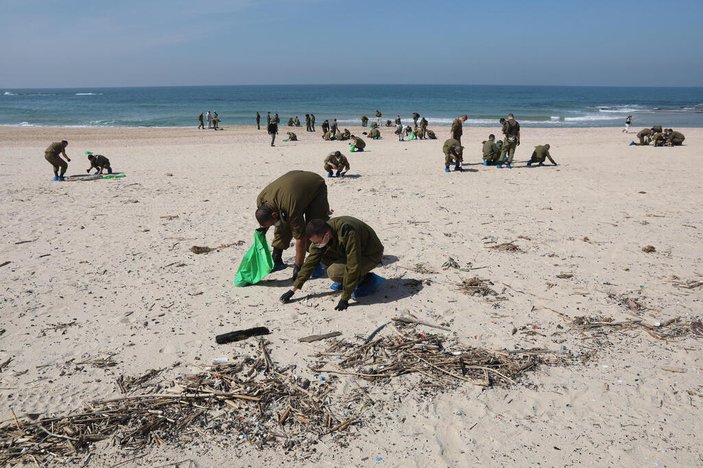 IDF soldiers cleaning the Palmachim Beach (Photo: EPA) IDF soldiers cleaning the Palmachim Beach