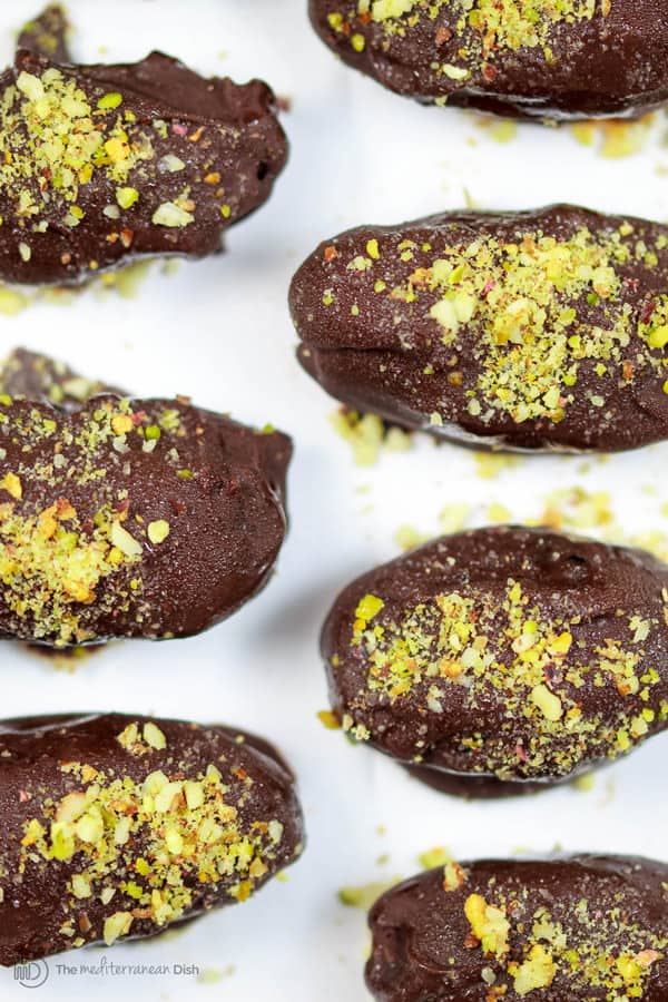 Chocolate Covered Date Recipe | The Mediterranean Dish. Melt-in-your-mouth soft medjool dates, stuffed with almonds and covered in chocolate! An easy make-ahead gluten free (and vegan) dessert. These homemade candy make the perfect edible gift!