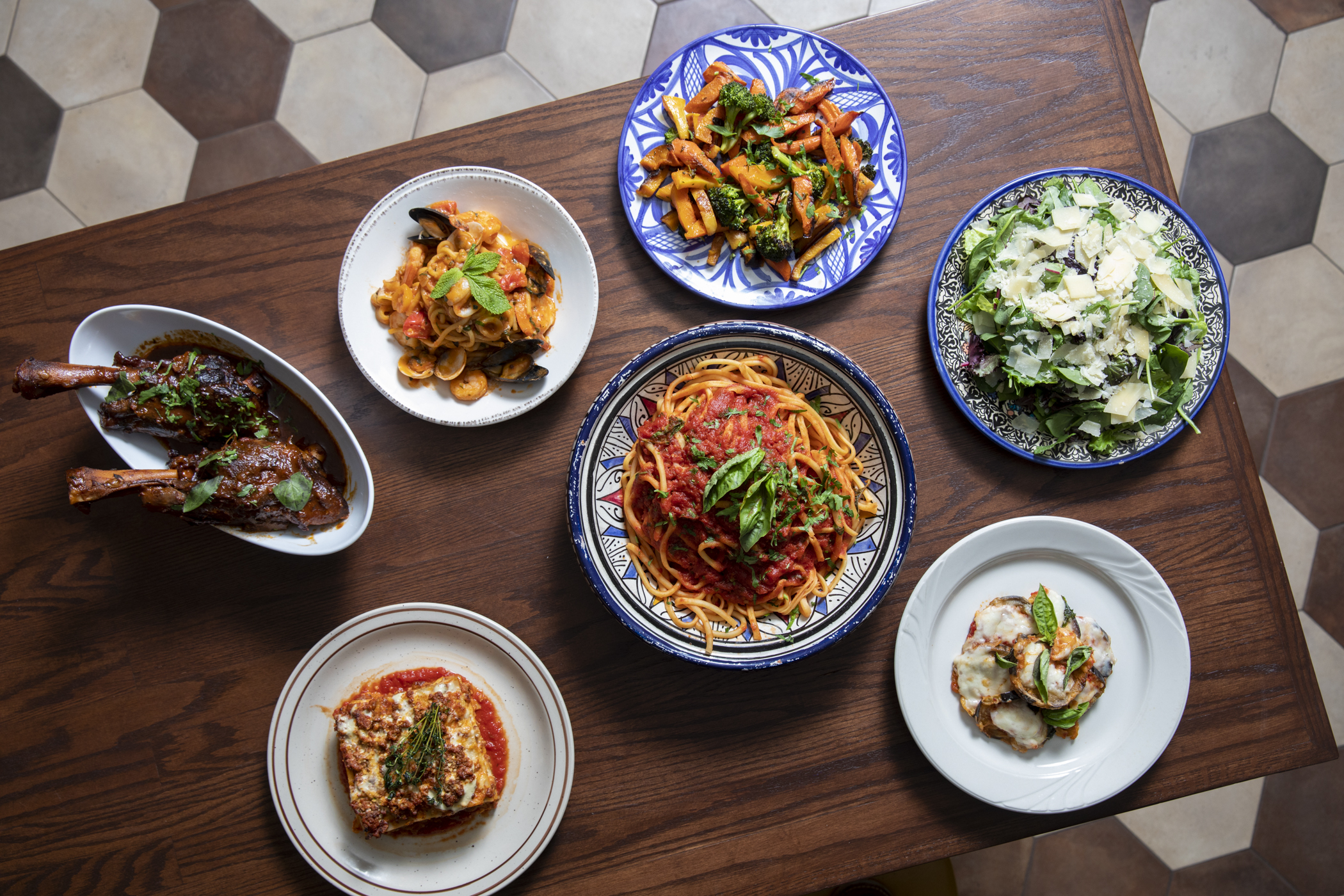 Italian dishes across a dark wood table.