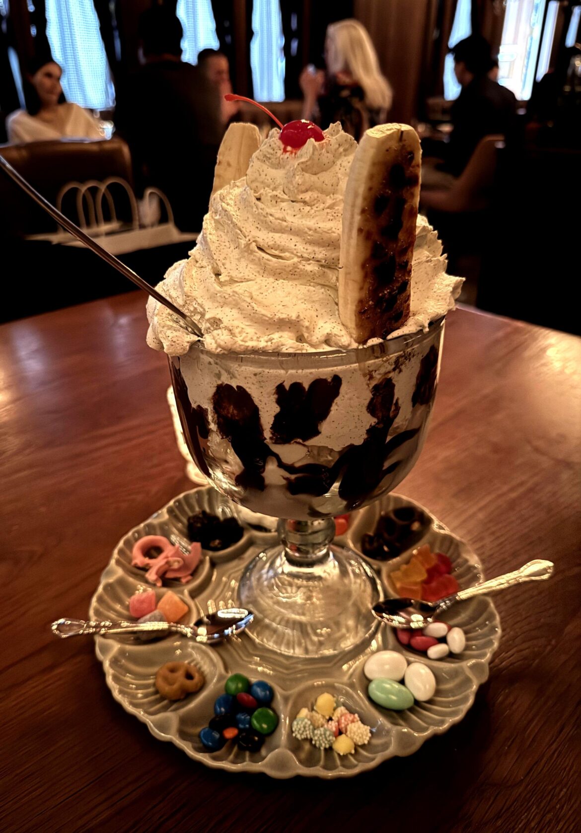 Ice cream sundae with brle bananas and whipped cream studded with vanilla bean