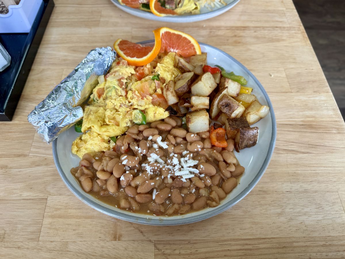 Eggs with beans and tortillas, and a side of potatoes, at Virgil Cafe