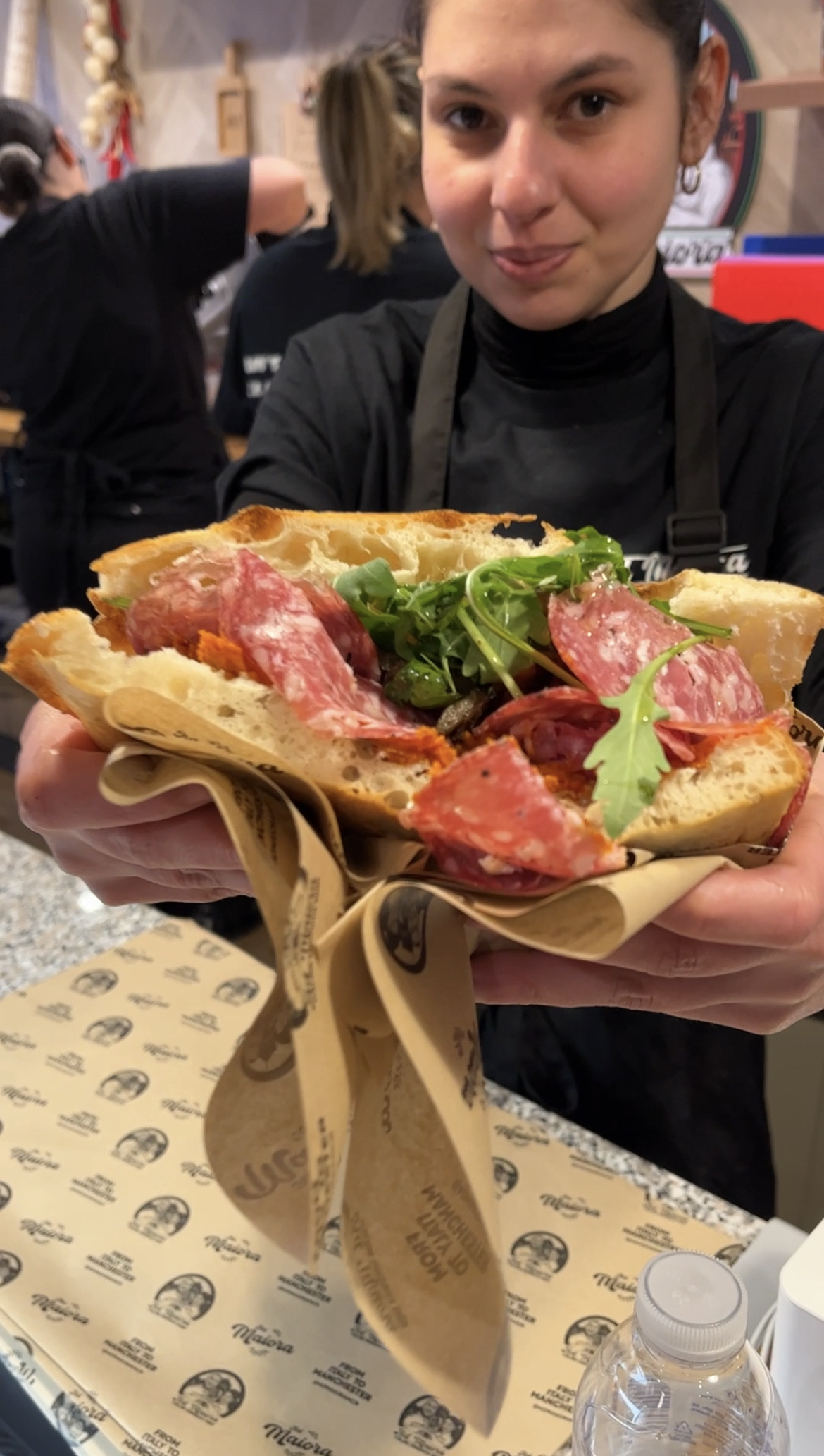 Ad Maiora owner Daniela holding sandwich with salami and rocket inside