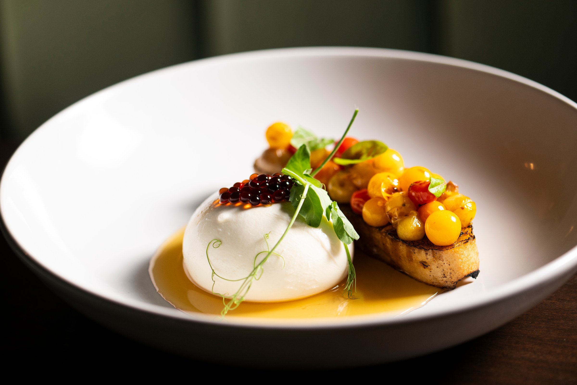 A plate of burrata with a mango crostini.