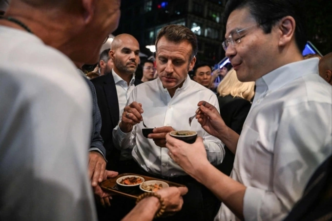 President Emmanuel Macron (C) and Prime Minister Lawrence Wong (R) dining at Lau Pa Sat. Photo courtesy of AFP