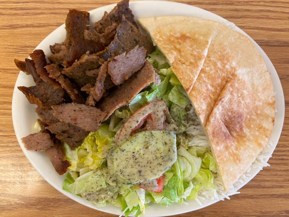Gyro plate with seasoned lamb and beef cooked on a spit, rice, salad and pita bread