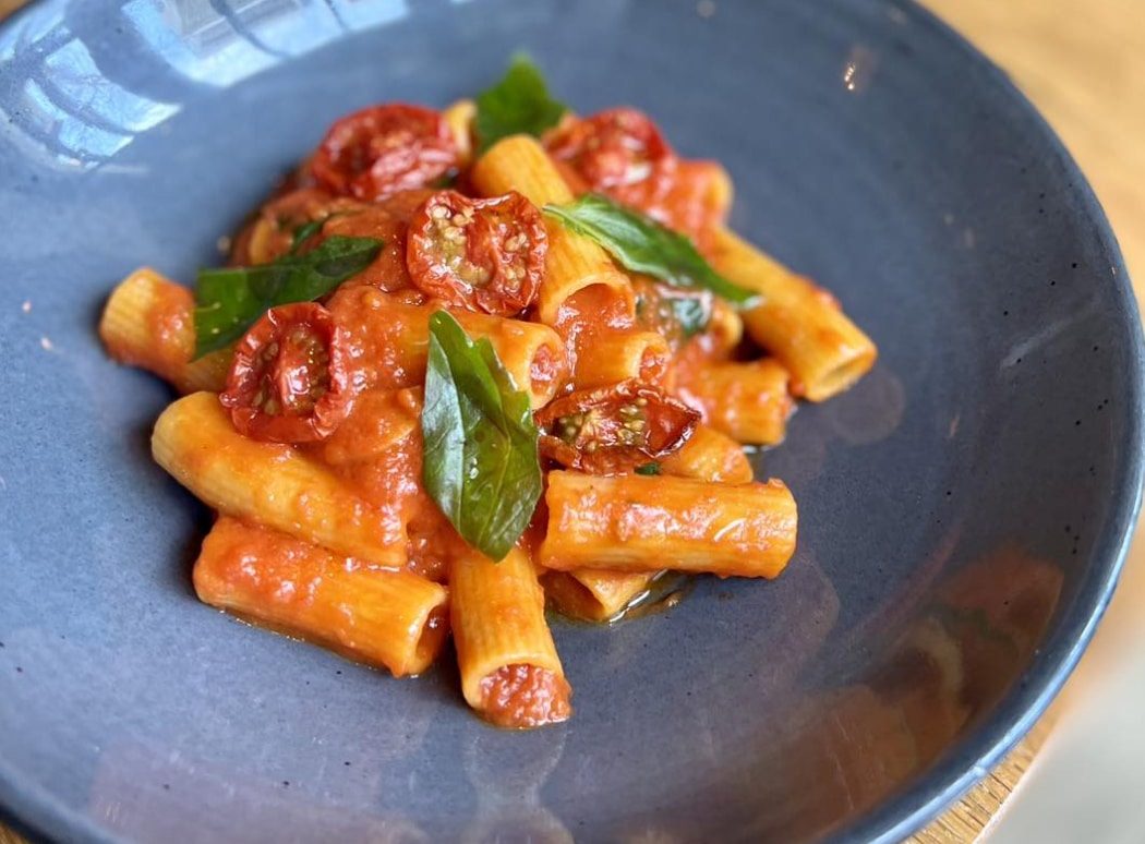 pasta with marinara tomatoes and basil in a blue bowl from monteverde in Chicago