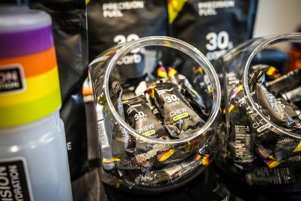 Several containers of Precision Fuel 30g carb chew in mint and lemon flavor.