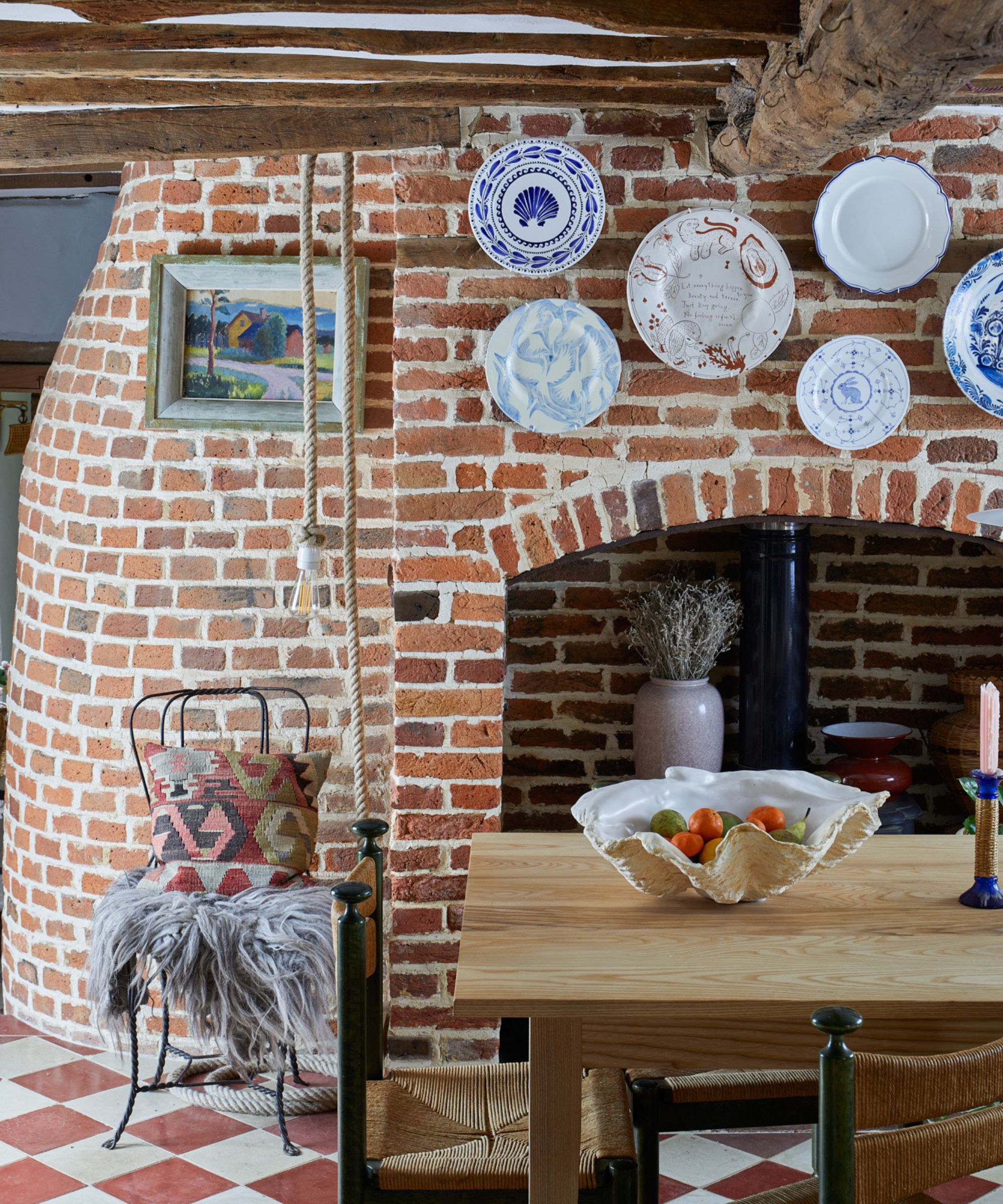 rustic dining space with exposed brick wall and hanging wall plates