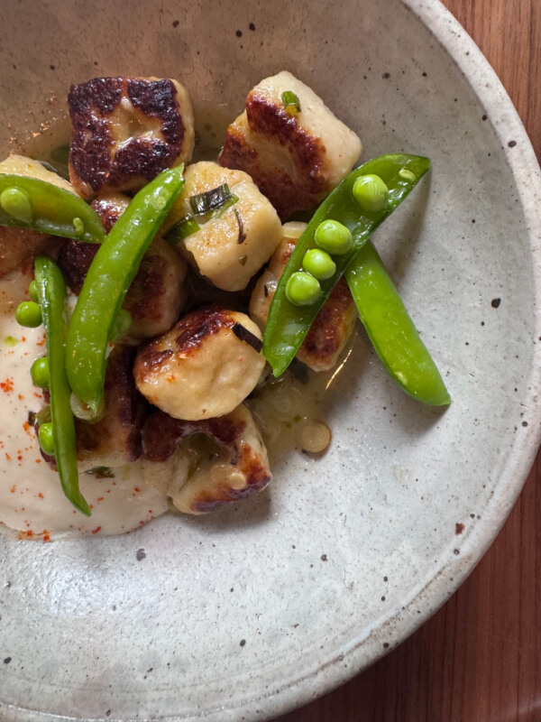 48 Hours in Asheville: A Culinary Tour Through an NC Gem - 13 Pan-seared gnocchi with snap peas and creamy white sauce, artfully presented in a ceramic bowl.