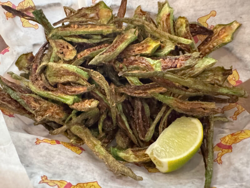48 Hours in Asheville: A Culinary Tour Through an NC Gem - 9 A basket of crispy fried okra strips, served with a wedge of lime on patterned paper.