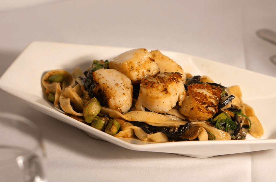 Italian scallops on top of pasta and wine sauce.