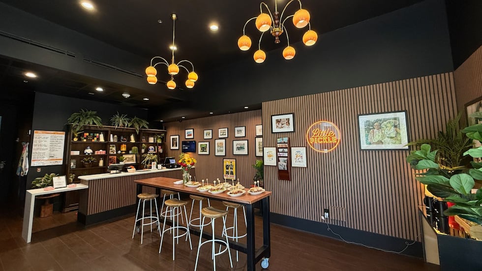 The restaurant features a nod to New York’s iconic delis through vibrant artwork and a Wall of...