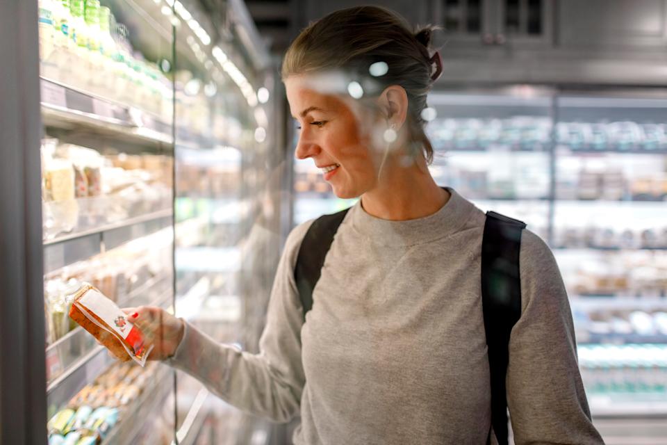 woman at grocery store looking at healthy food 