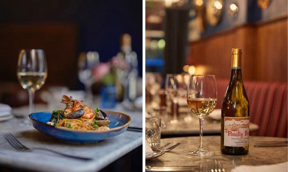 Bowl of seafood pasta with bottle of white wine