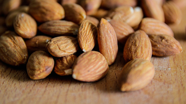 Loose almonds on wooden surface