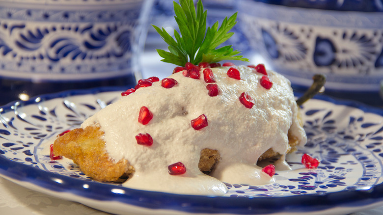Authentic chiles en nogada, roasted and stuffed poblano pepper with walnut white sauce and pomegranate