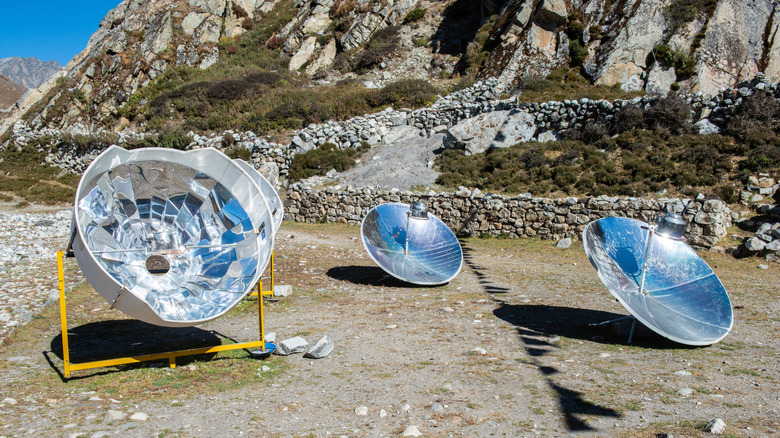 solar cookers being used to boil water in kettles