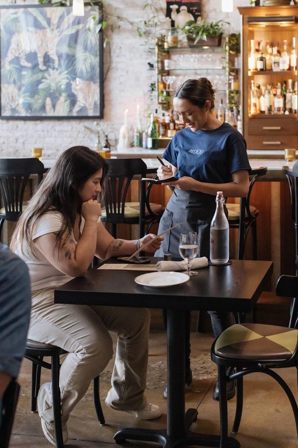A guest sits down to dinner during the restaurant's friends and family service.