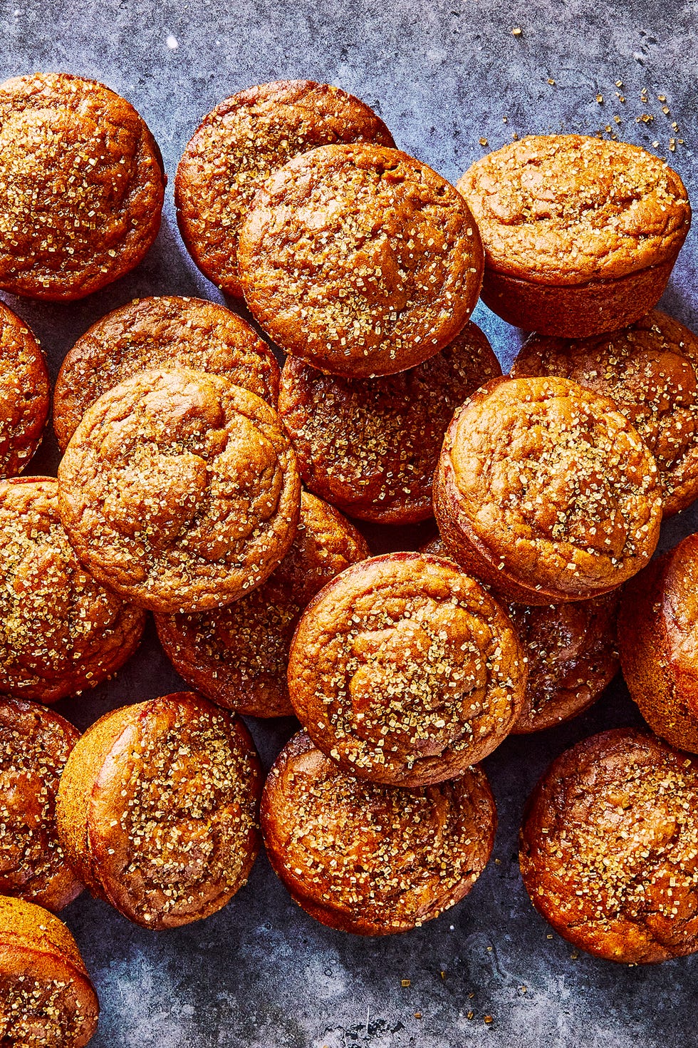 a pile of pumpkin muffins topped with coarse sugar