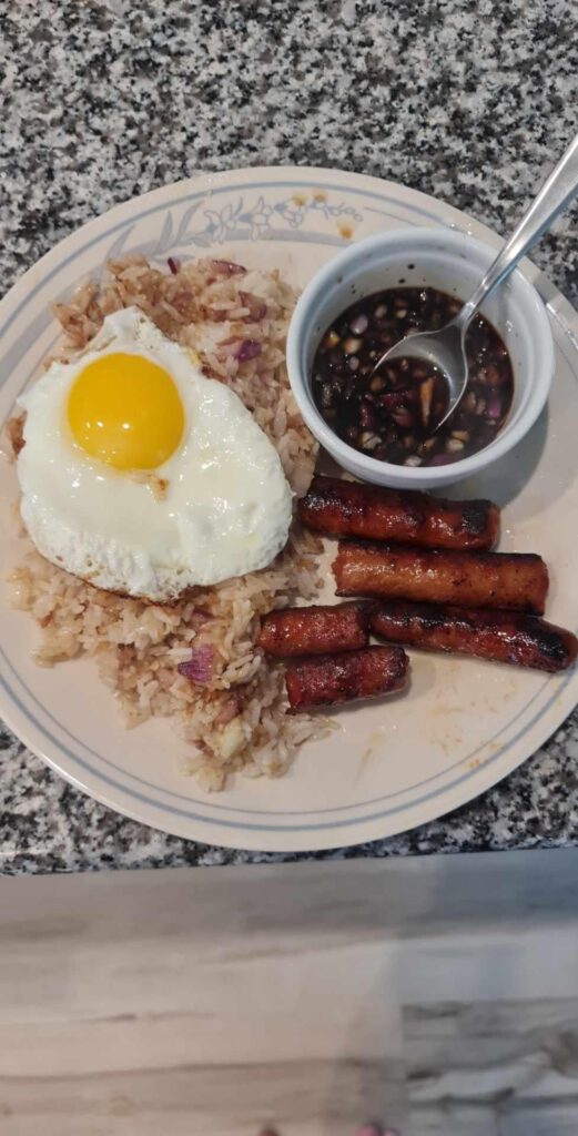 Filipino breakfast, fried garlic rice, egg, longinisa, and sawsawam.