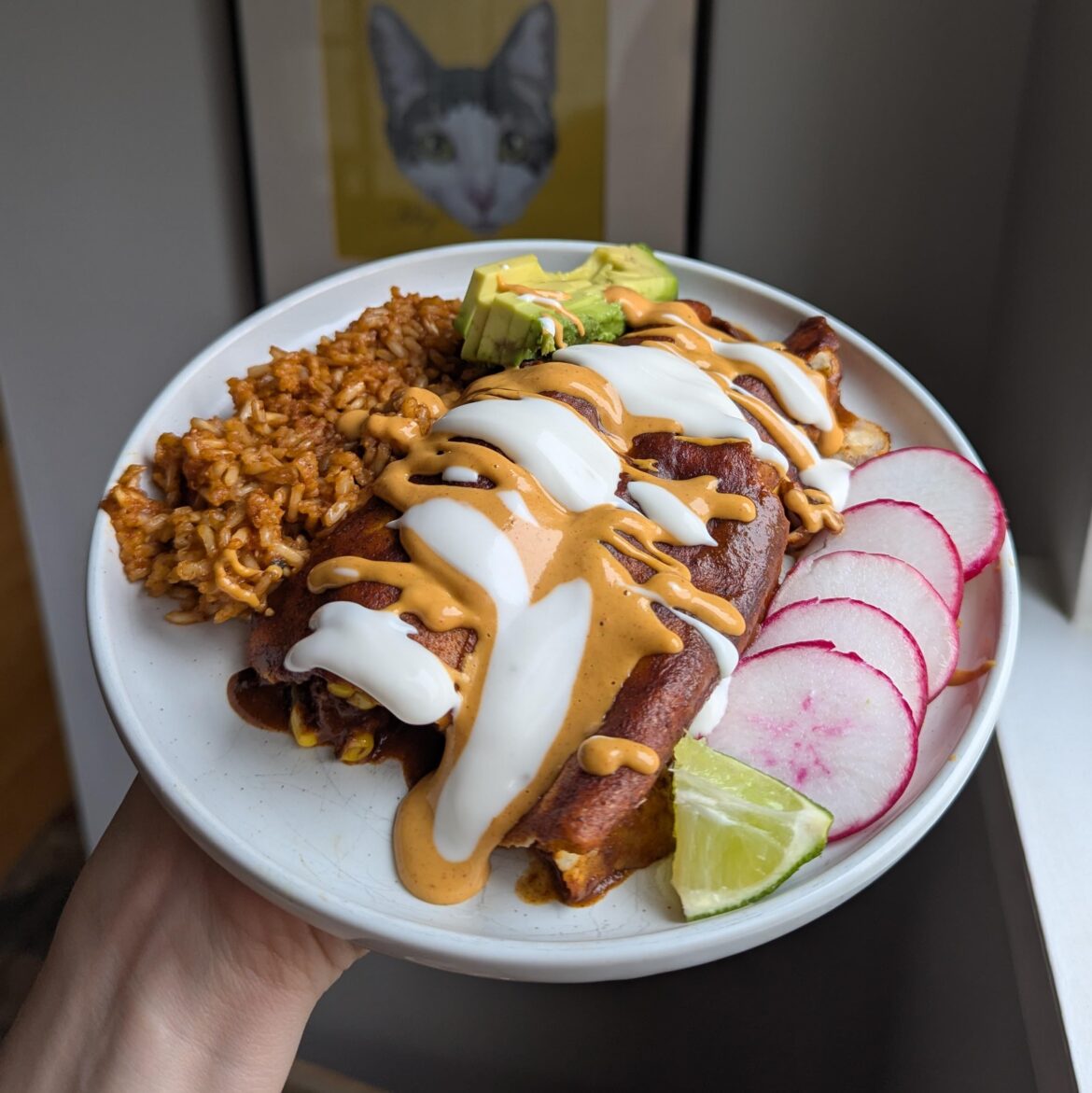 sweet potato and black bean enchiladas with chipotle sauce and crema.