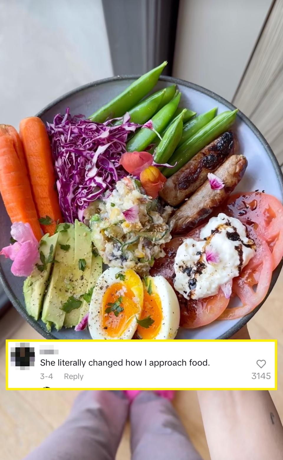 A colorful bowl with carrots, snap peas, red cabbage, grilled meat, creamy topping, tomatoes, avocado slices, and halved boiled eggs