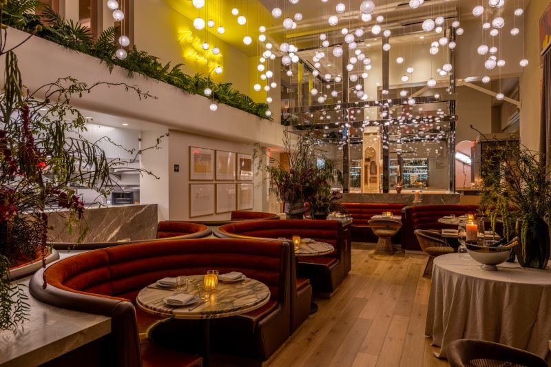 Red circular dining booths and suspended lights in the dining room at Funke.