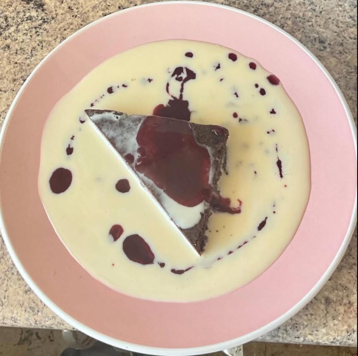Keto chocolate brownie with crème anglaise and raspberry sauce.
