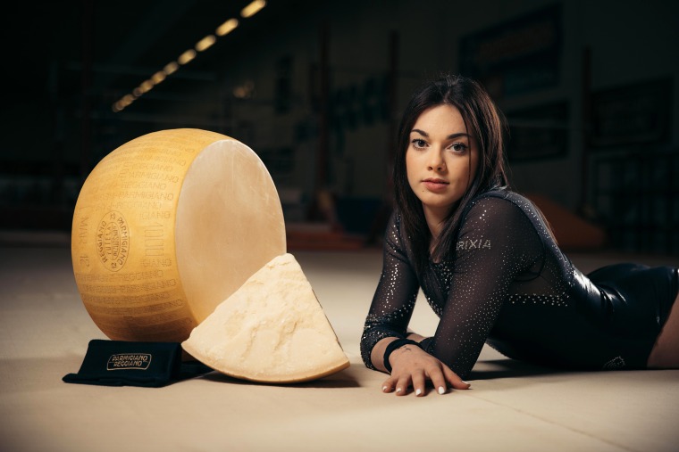 Italian silver medalist Giorgia Villa with a wheel of Parmigiano Reggiano.
