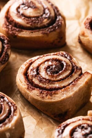 unfrosted cinnamon roll on parchment paper