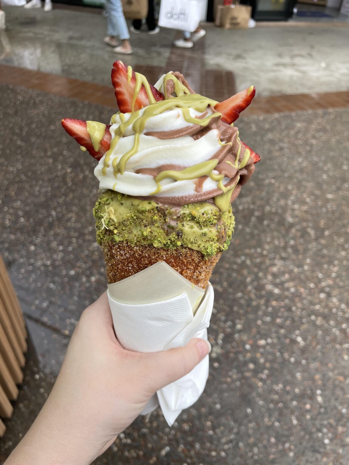 cinnamon sugar chimney cake stuffed with kataifi, strawberries and pistachio cream, topped with choc vanilla swirl and more pistachio cream and strawberries