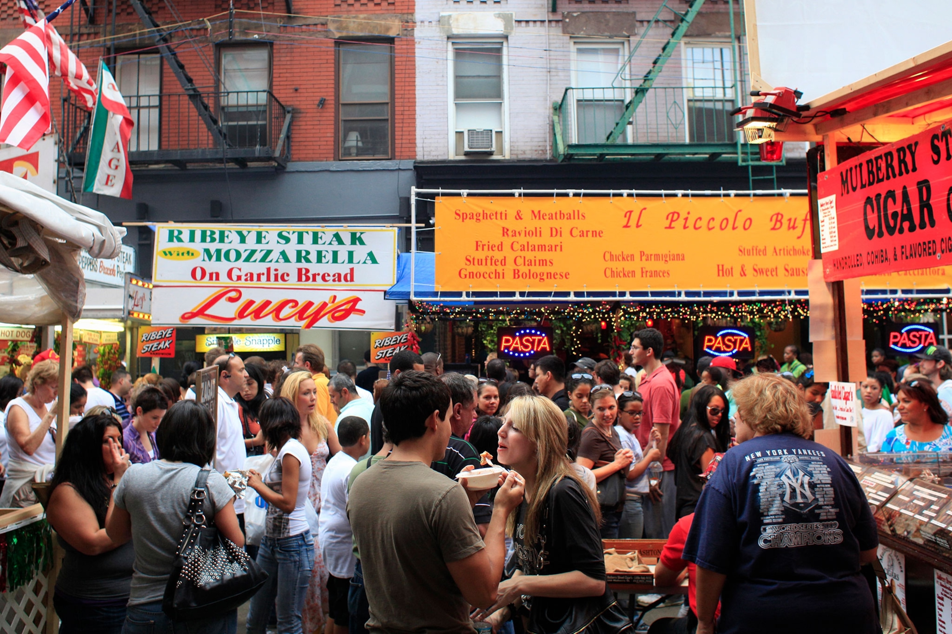 People eating and gleefully enjoying the a festival during the day.