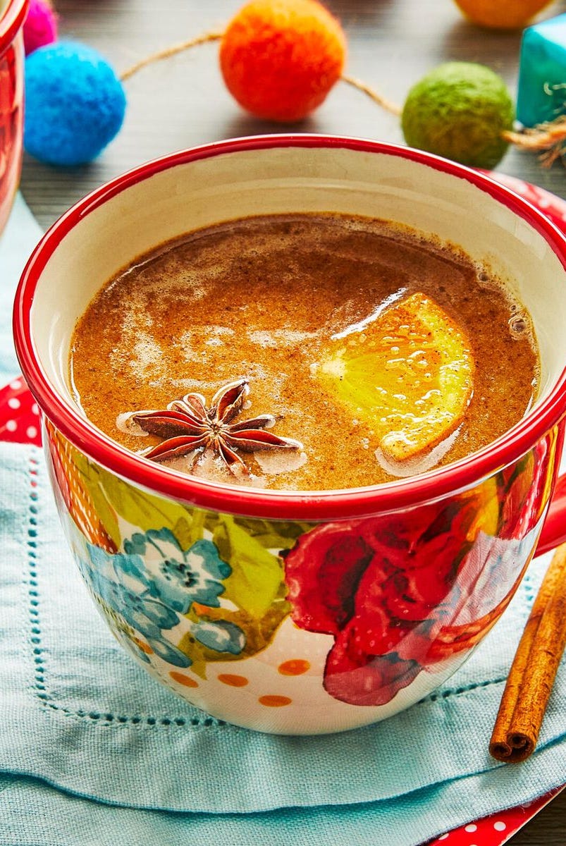 a mug of hot buttered rum with star anise and orange