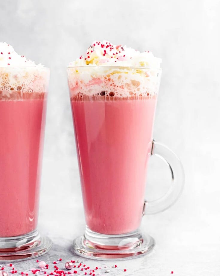 red velvet hot chocolate with whipped cream and red and pink sprinkles
