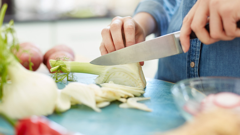 A woman's hands chopping a fennel bulb