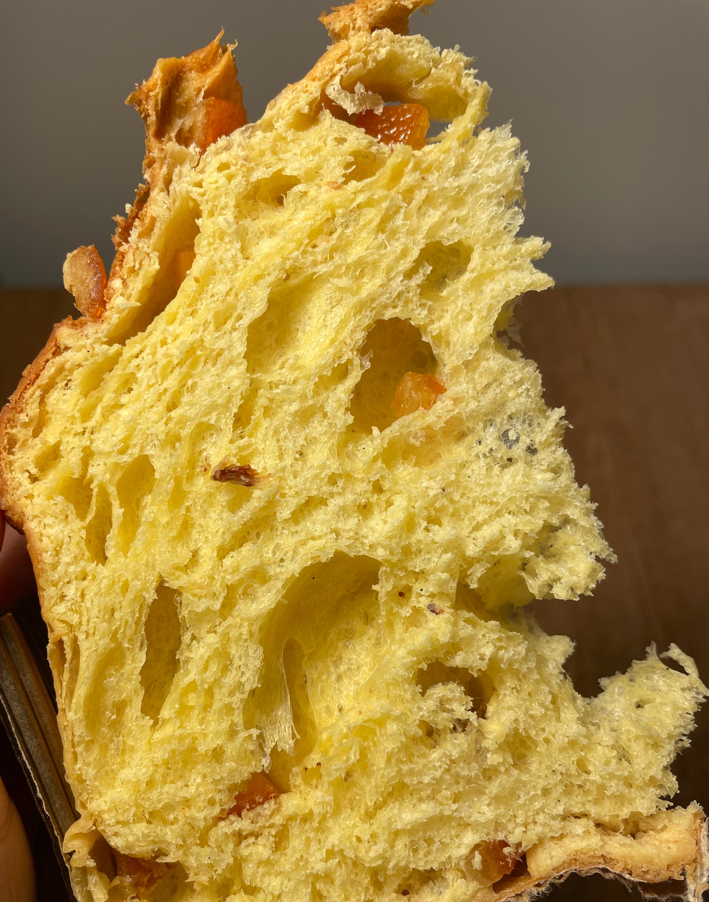 A close-up of a yellow panettone interior, with chunks of candied fruit.