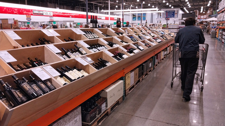 Costco customer walking through wine aisle
