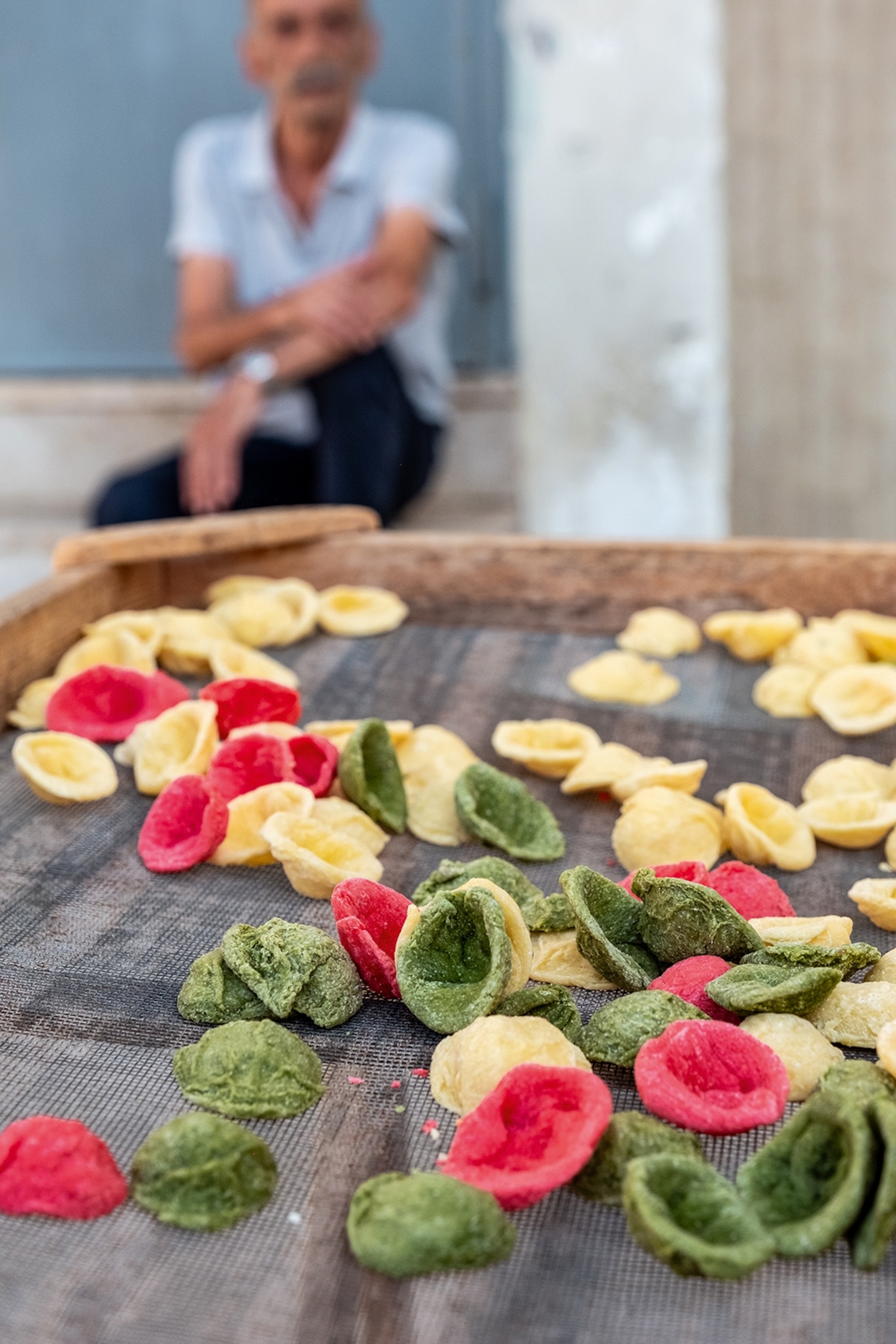 Fresh coloured pasta laid out on a patterned cloth