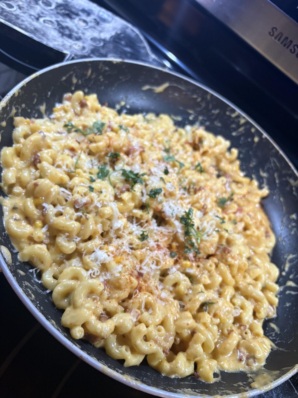 Homemade southwest Mac n Molded cow titty juice with Bacon, sautéed Garlic, Jalapeño, Corn, Roma, Cheddar, Fresca , Gruyère, garnished with Parm, Cilantro, Cayenne pepper, and red pepper flakes.