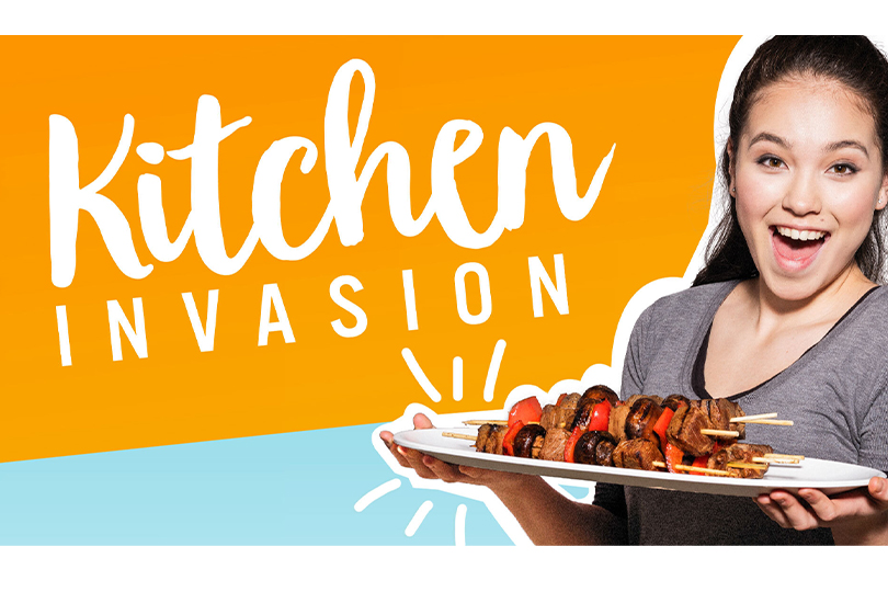 Alexa Curtis holding a plate of food in a kitchen